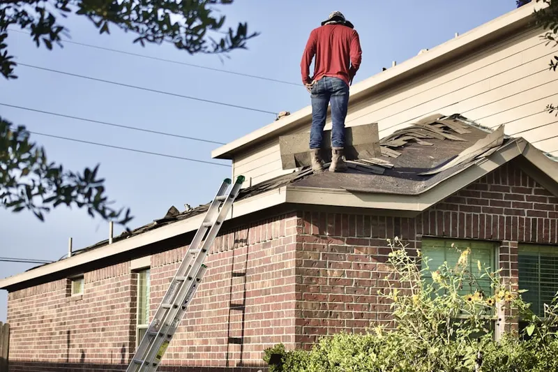 Professional roofer working on a residential roof in Spring Arbor